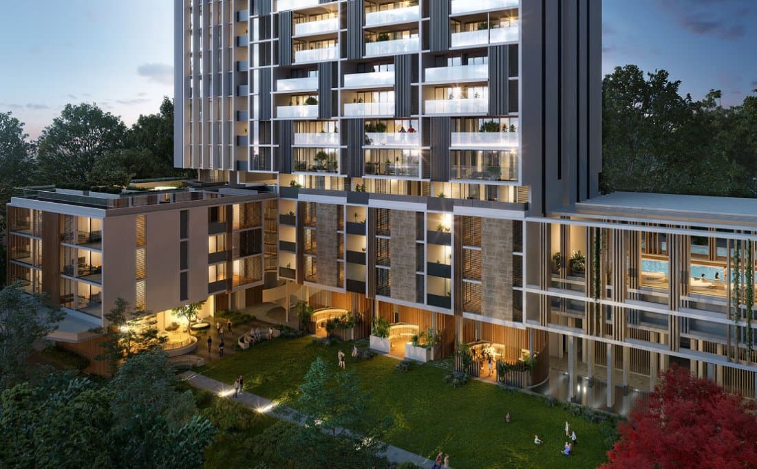 An apartment building at dusk, with a landscaped courtyard